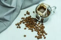 ground, a bag for coffee drops and a transparent mug on the table. Drop coffee on a gray background with coffee beans.