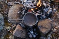 Ground black coffee in a copper Turk is brewed and boils on camp fire. Royalty Free Stock Photo