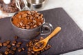 Ground black coffee in a black cup and several roasted coffee beans on top Royalty Free Stock Photo