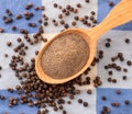 Ground black pepper in a spoon and pepper peas, background. The view from top Royalty Free Stock Photo