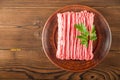 Ground chicken with a sprig of parsley on a wooden plate on a textural table. Turkey mince raw close-up and copy space Royalty Free Stock Photo