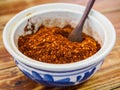 ground chilli peppers in ceramic bowl on wooden table. Food concept Royalty Free Stock Photo