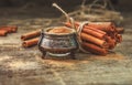 Ground cinnamon, cinnamon sticks, tied with jute rope on old wooden background in rustic style Royalty Free Stock Photo