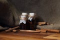 Ground cinnamon, essential oil and cinnamon sticks cinnamon on a darck wooden background.