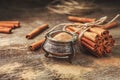 Ground cinnamon, cinnamon sticks, tied with jute rope on old wooden background in rustic style. Royalty Free Stock Photo