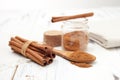 ground cinnamon in wooden spoon and cinnamon sticks on white background Royalty Free Stock Photo