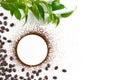 Ground and coffee beans on white background with green leaves