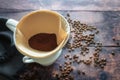 Ground coffee in a paper filter bag and in a porcelain holder on a mug for an aromatic drip brewed hot drink, rustic wooden table Royalty Free Stock Photo