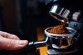 Ground coffee pouring into a portafilter with a grinder Royalty Free Stock Photo