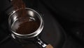 Ground coffee pouring into portafilter from grinder Royalty Free Stock Photo