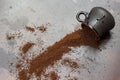 Ground coffee are scattered from black cup onto table Royalty Free Stock Photo