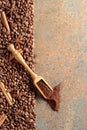 Ground coffee in a spoon and coffee beans with cinnamon and anise on a rusty metal background Royalty Free Stock Photo