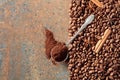 Ground coffee in a spoon and coffee beans with cinnamon and anise on a rusty metal background Royalty Free Stock Photo