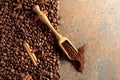 Ground coffee in a spoon and coffee beans with cinnamon and anise on a rusty metal background Royalty Free Stock Photo