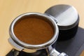 Ground coffee tamped in portafilter and coffee leveler