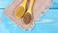 Ground cumin in a spoon and whole cumin on the wooden background. Royalty Free Stock Photo