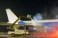 Ground deicing of a big cargo airplane on the night airport apron