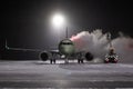 Ground deicing of a passenger airliner on the night airport apron at winter