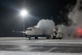 Ground deicing of a passenger airliner on the night airport apron at winter