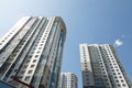 Ground diagonal view of high modern luxury tiled apartment building on blue sky background. Royalty Free Stock Photo