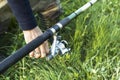 Ground fishing. Angler`s hand adjusts the tension of the fishing line with the reel. Royalty Free Stock Photo