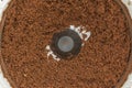 Ground grilled dark coffee beans in an automatic coffee grinder, close-up of food background Royalty Free Stock Photo