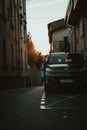 Ground-level shot of a black car in a narrow street in Saint Jean De Luz at sunrise