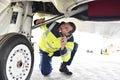 Ground personnel at the airport check the hydraulic system of th