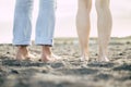 Ground and rear view of feet from man and woman couple in friendship or relationship - naked nude young bodies enjoying the sand