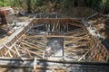 The ground recessed pool in the process of construction. Masonry formwork reinforced with bamboo trunks. Excavated clay piled up
