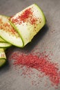 Ground Red Sumac Berries sprinkled on cucumber slice Royalty Free Stock Photo