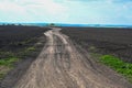 Ground road leaving to the horizon. Agriculture plowed field. Black soil plowed field. Tillage soil prepared for planting crop. Royalty Free Stock Photo