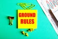 GROUND RULES are written in red on a yellow sticker on a green background next to a graph, pencil, and yellow buttons and paper Royalty Free Stock Photo