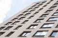 Ground view, low angle view of high modern apartment building with beige pargeted walls and wide windows reflecting sky Royalty Free Stock Photo