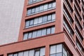 Ground view of modern building facade with red concrete walls, balcony windows Royalty Free Stock Photo