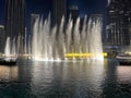 Ground view of partial downtown Dubai with lighted water fountain at night