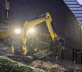 Ground worker working at night in bad rainy weather, constructing a garden in the evening Royalty Free Stock Photo