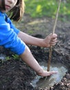 Grounded child playing with mud and stick for nature discovery Royalty Free Stock Photo