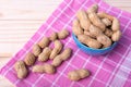 Groundnuts in bowl on cloth on wooden table Royalty Free Stock Photo