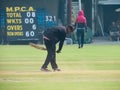 Groundsman sweeping away dirt from cricket pitch. Royalty Free Stock Photo