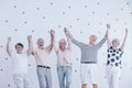 Group of active elderly people holding hands up and enjoying meeting Royalty Free Stock Photo