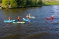 Group of active tourists stand up paddling on sup boards