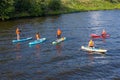 Group of active tourists stand up paddling on sup boards