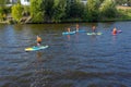 Group of active tourists stand up paddling on sup boards