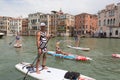 Group of active tourists stand up paddling on sup boards at Grand Canal, Venice, Italy.