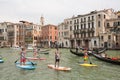 Group of active tourists stand up paddling on sup boards at Grand Canal, Venice, Italy.