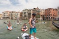 Group of active tourists stand up paddling on sup boards at Grand Canal, Venice, Italy.