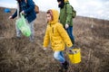 Group of activists picking up litter in nature, environmental pollution concept.