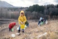 Group of activists picking up litter in nature, environmental pollution concept.