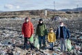 Group of activists standing on landfill, environmental pollution concept.